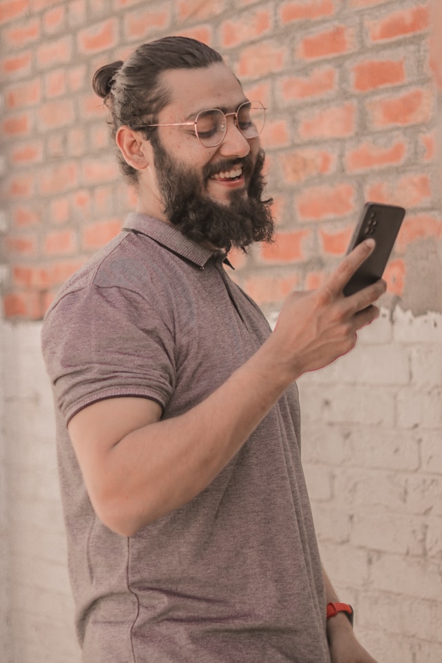 Hombre sonriendo en el telefono por ver un anuncio